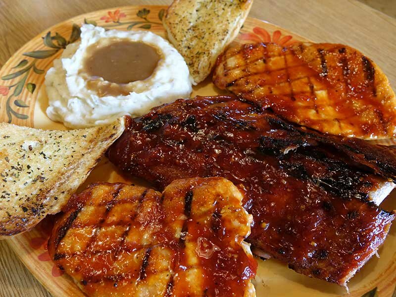 Closeup shot of ribs, grilled chicken and garlic bread with mashed potatoes