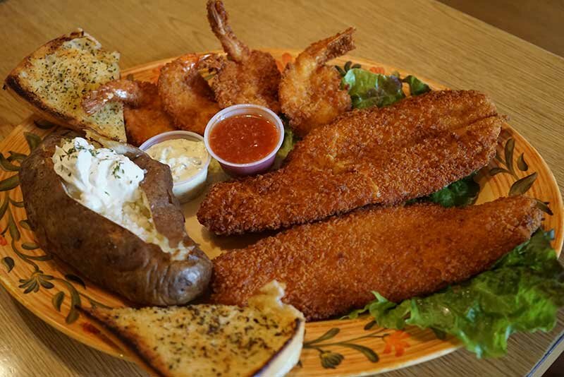 Fried fish, fried shrimp, garlic bread and baked potato