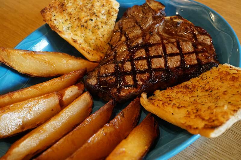 Plated steak with steak fries and garlic bread
